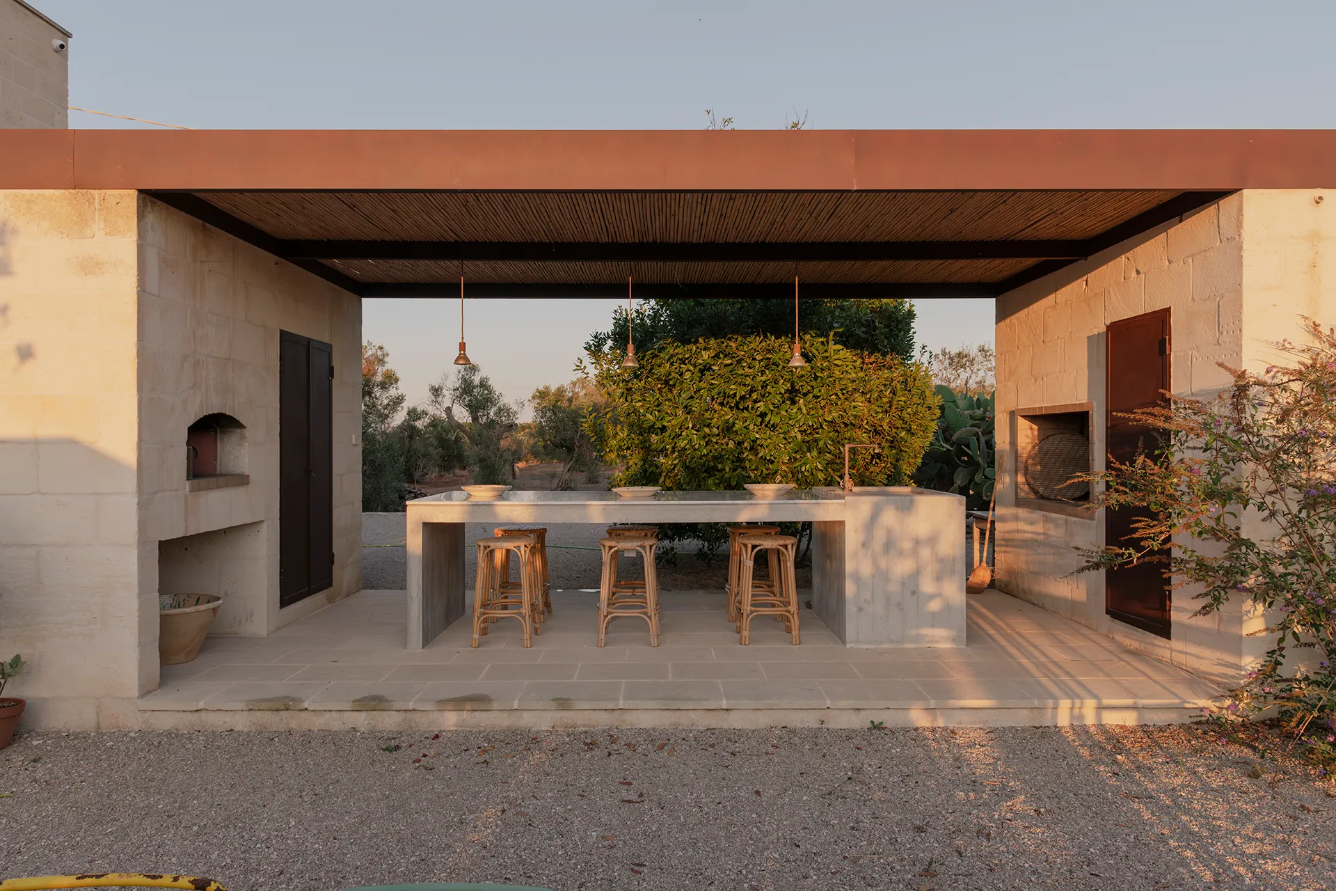 Cucina esterna con forno pizza e tavolo conviviale